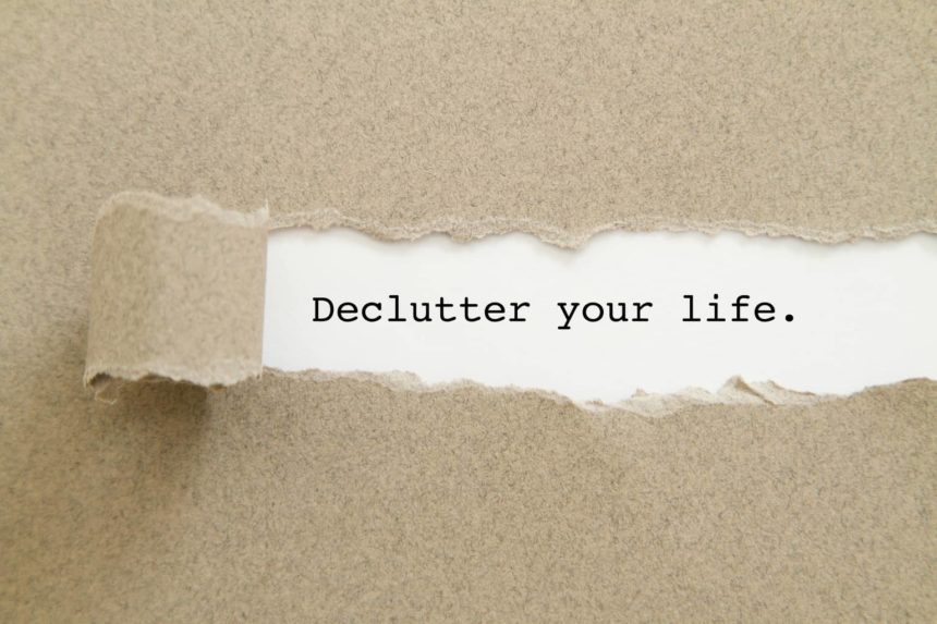 Declutter your life word written under torn paper.
